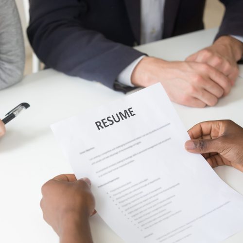 African american applicant holding curriculum vitae at interview, black unemployed job seeker giving hr cv at hiring negotiations, employment and recruiting concept, focus on resume, close up view